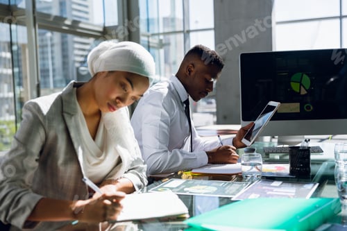 Preview: Male and females executives working together at desk