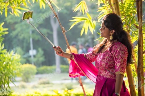 Preview: Beautiful young girl taking selfie with selfie stick