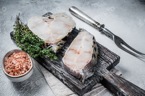 Preview: Raw wolffish fillet fish Steak on wooden cutting board. White background. Top view