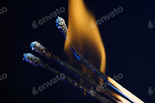 Preview: Closeup of burning matches isolated on a dark blurry background