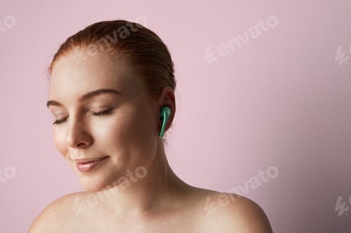 Preview: Portrait of charming redhead woman with romantic smile and closed eyes listening music