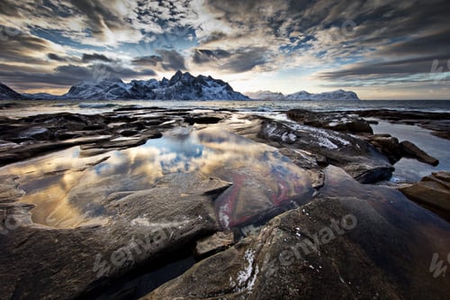Preview: Landscape of rocky mountains covered in the snow surrounded by water in Lofoten, Norway