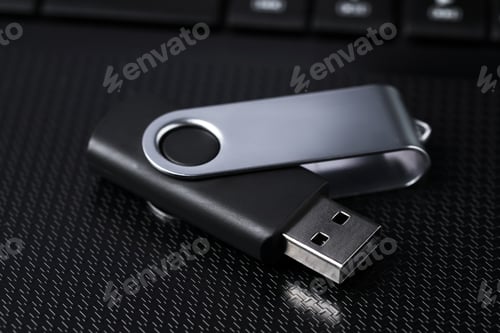 Preview: Modern usb flash drive on laptop, closeup
