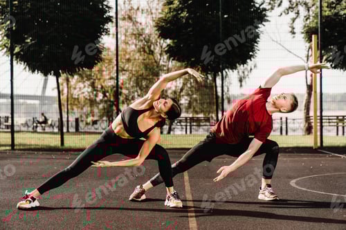 Preview: Young fit caucasian couple warming-up on the sporting ground