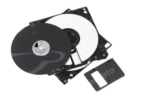 Preview: Old computer disks stacked together showing wear and tear in a cluttered workspace