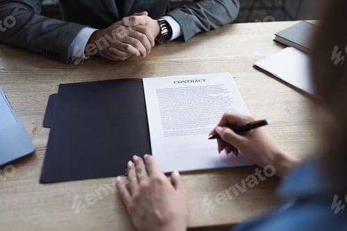 Preview: Cropped view of woman holding pen near contract and businessman during job interview