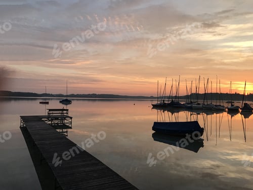 Preview: Wide shot of a dock and boats on the body of water during sunset