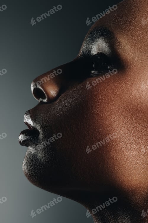 Vista previa: profile view of attractive elegant african american girl posing for fashion shoot, isolated on grey