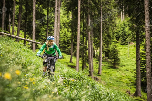 Preview: Woman mountain biking on hillside, Meran, South Tyrol, Italy
