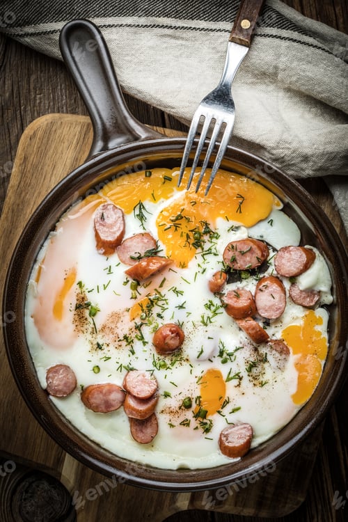 Preview: Tasty cooked egg with chopped sausages.