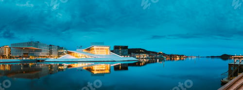 Preview: Oslo Norway. Evening View Of Illuminated Opera Ballet House Among High-Rise Buildings Under Blue Sky