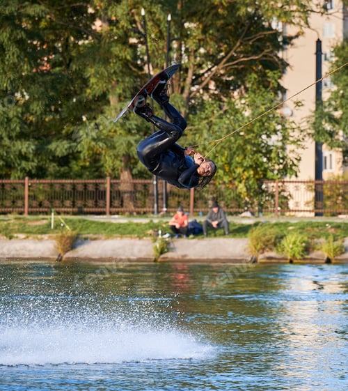 Preview: Young surfer having fun wakeboarding in the cable park.