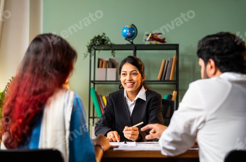 Preview: Meeting young couple in modern office discussing on graph, Indian young financial planner