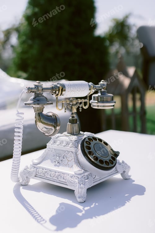 Preview: Closeup of a vintage rotary telephone on a white table in a wedding venue