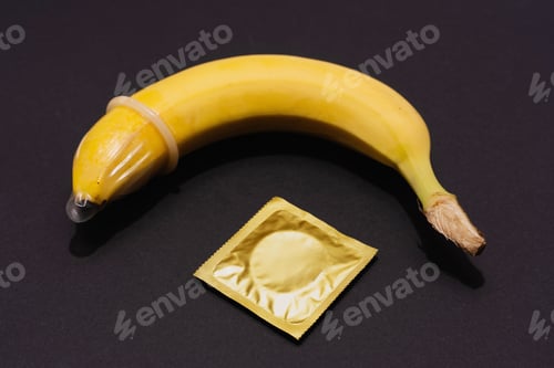 Preview: Banana with Condom on black background. Sexual Health and Education Concept