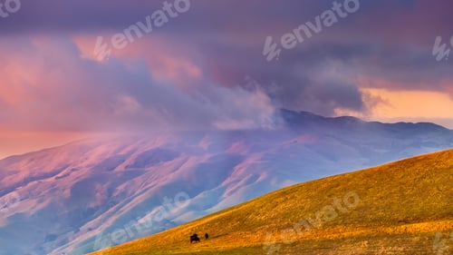 Preview: Sunset view of storm clouds covering the top of a mountain