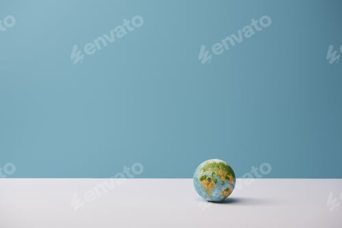 Preview: small globe on white table and blue background