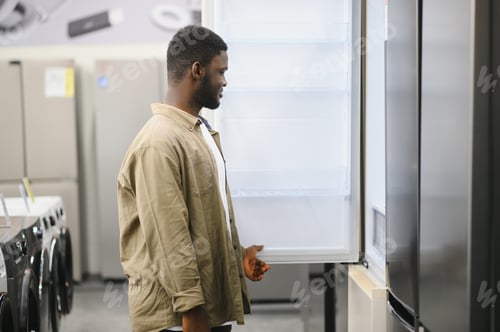 Preview: Man choosing fridge in the shop