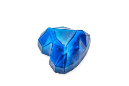 Preview: Chocolates in the form of precious stones - sapphire in the shape of a heart on a white background.