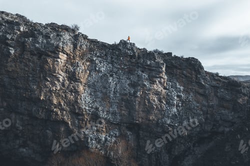 Preview: Professional mountain climber posing at the peak of mountain