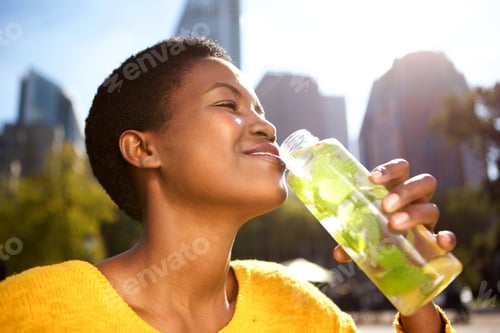 Preview: healthy young woman drinking water outdoors