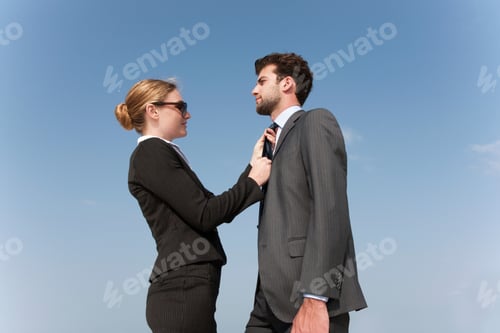 Preview: Businesswoman adjusting colleague?s tie