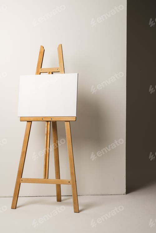 Preview: Easel with Blank Canvas Against White Wall