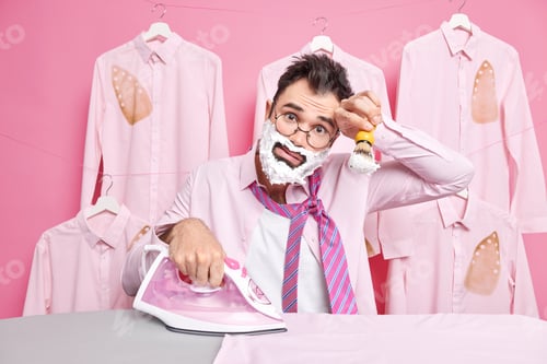 Preview: Tired man being in hurry prepares for corporate party dresses and shaves quickly wears shirt with ti