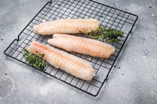 Preview: Fresh raw cod fish fillet, Boneless white fish meat. gray background. top view