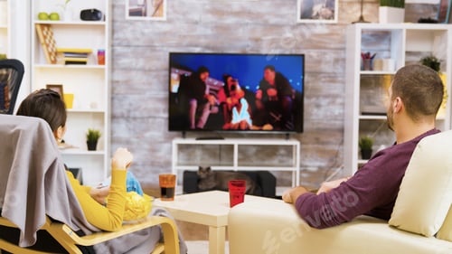 Preview: Young couple sitting comfortable on in front of tv