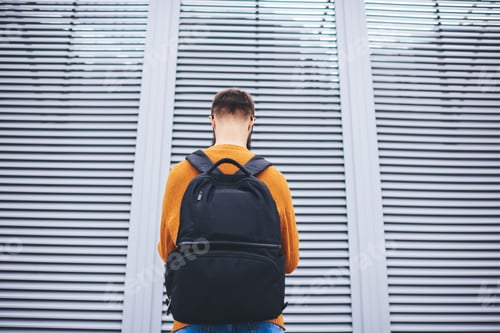 Preview: Man with backpack against modern building