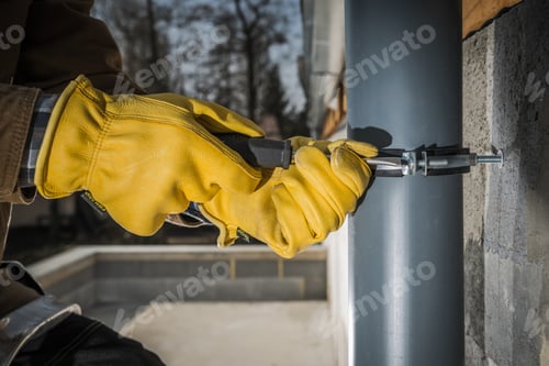 Preview: Construction Worker Attaching Home Gutters to the Building Wall