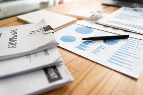 Preview: Paper report. Blue graphs and charts. Business reports and a pile of documents on a wood table backg
