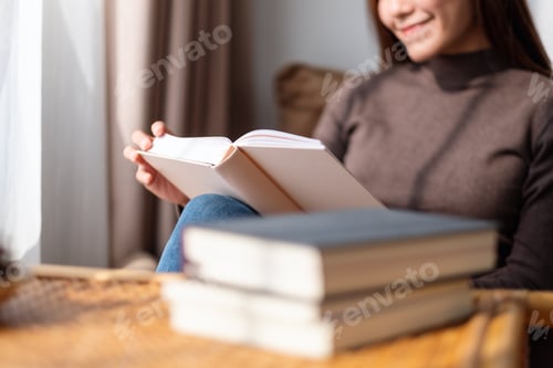 Vorschau: Nahaufnahme einer schönen jungen asiatischen Frau, die zu Hause ein Buch liest