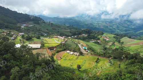 Preview: Aerial view of rural village and mountain road on cloudy day by drone