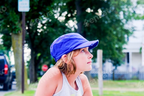 Preview: Profile portrait of girl in park wearing baseball cap