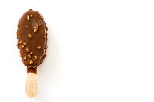 Preview: Chocolate ice cream bar covered with nuts on white background