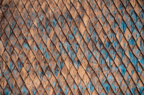 Preview: Old weathered wooden wall with ornament painted in brown and blue. Vintage texture Background.