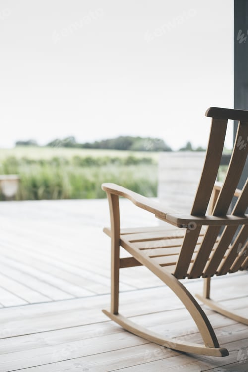 Preview: Vertical shot of a wooden chair on the porch with a blurred background