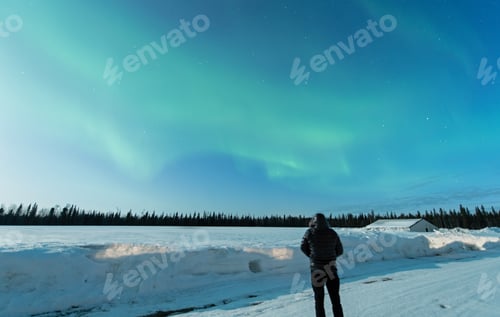 Preview: Man watching the northern lights in Alaska.