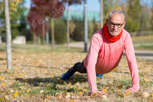 Preview: Senior man stretching after jogging in the park