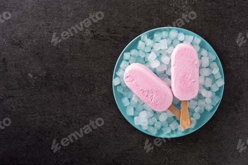 Preview: Strawberry popsicles and crushed ice on blue plate and yellow