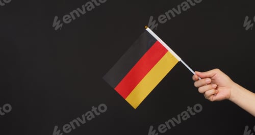 Preview: Hand is hold german flag on black background