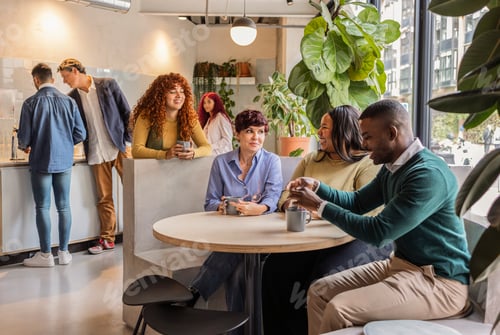 Preview: Diverse business team enjoying coffee break in modern office