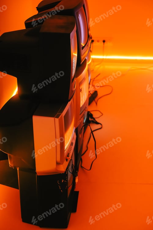 Preview: Old vintage tvs on a floor in a room with colored neon light.