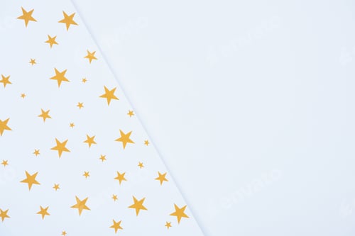 Preview: elevated view of festive paper decorated by golden stars isolated on white