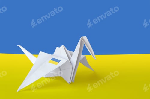 Preview: Ukraine flag depicted on paper origami crane wing. Oriental handmade arts concept