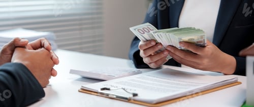 Preview: Businesswoman counting a thick stack of american one hundred dollar bills to pay an employee or a cl