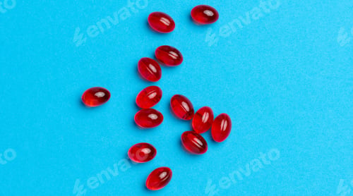 Preview: Orange capsules with fish oil on a blue background, top view