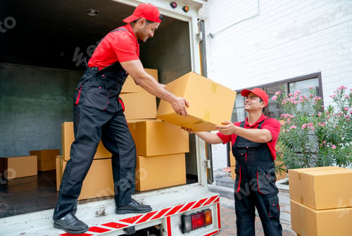 Preview: Close up of delivery man stand on truck and send parcel or box to his co-worker during transport